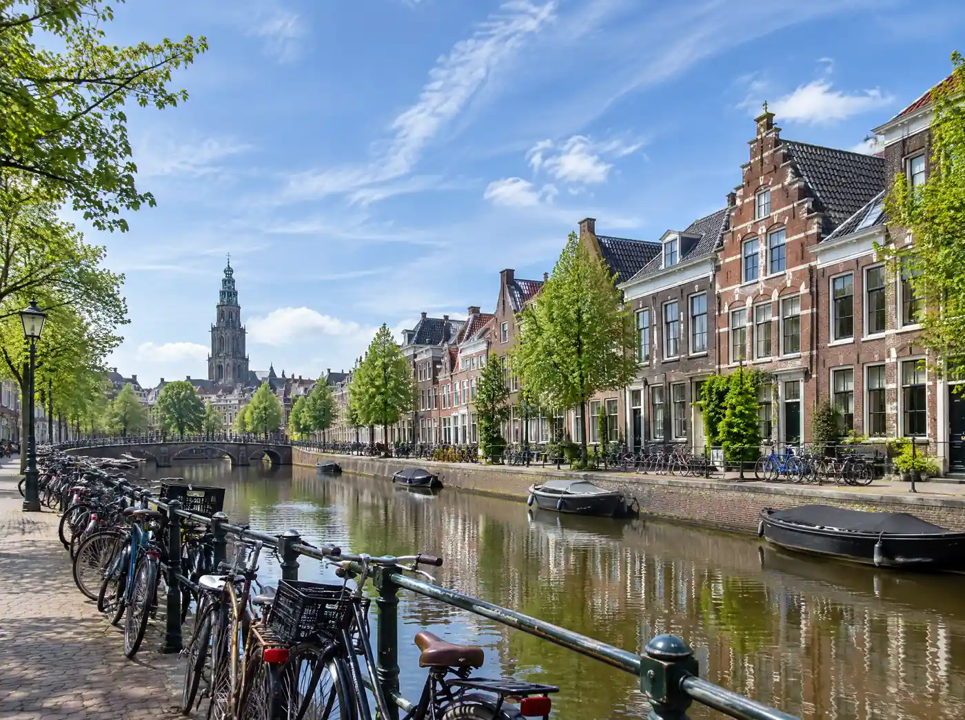 Fietsen langs een gracht met studentenhuizen in Groningen